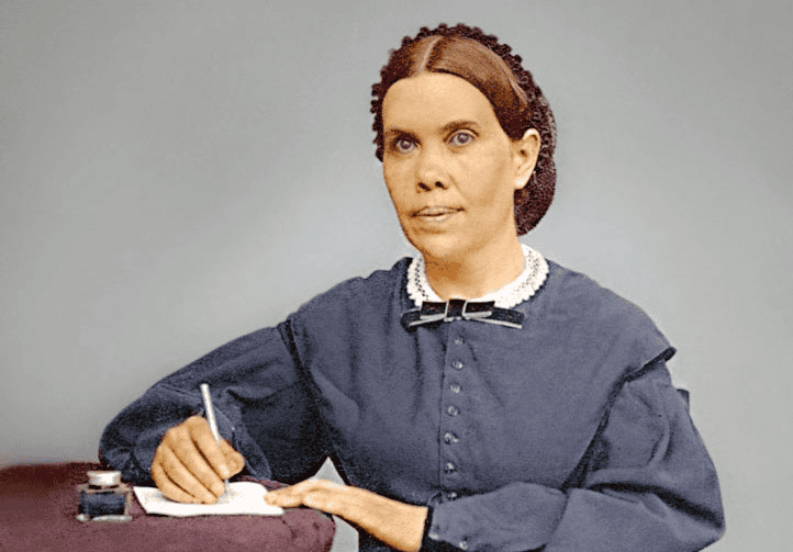 Historical figure in 19th century dress writing at desk with pen and paper