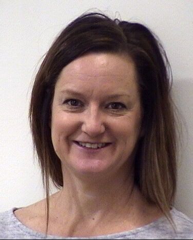 Professional headshot of smiling healthcare provider with brown hair against white background