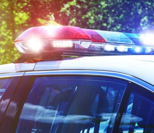 Police car with flashing red and blue emergency lights activated