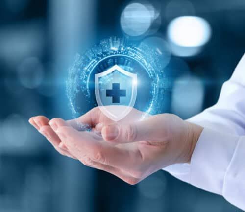 Doctor's hand holding holographic shield with medical cross and digital health protection symbols