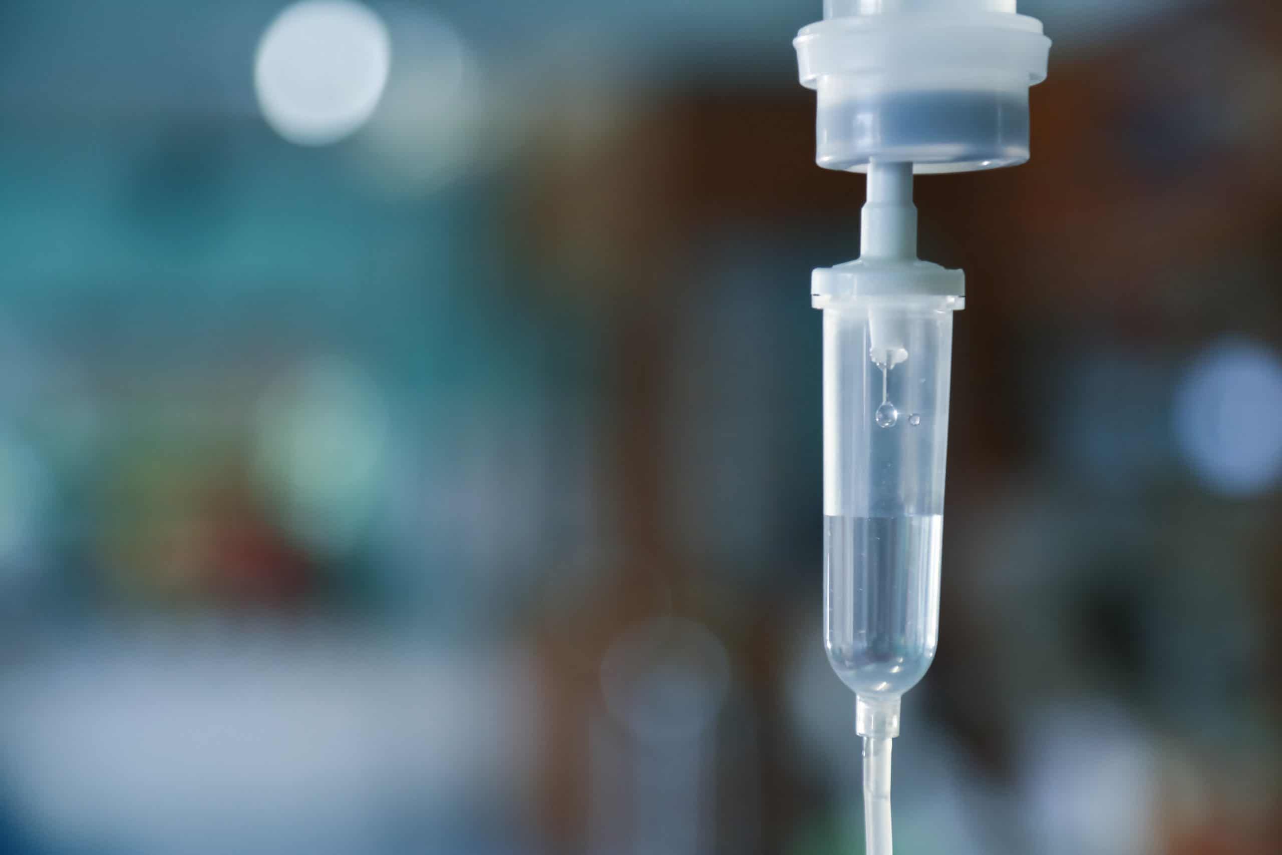 Medical IV drip bag and tubing in hospital setting with blurred background