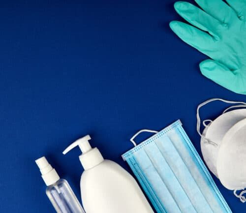 COVID-19 protection items: N95 mask, surgical masks, gloves, and hand sanitizer bottles