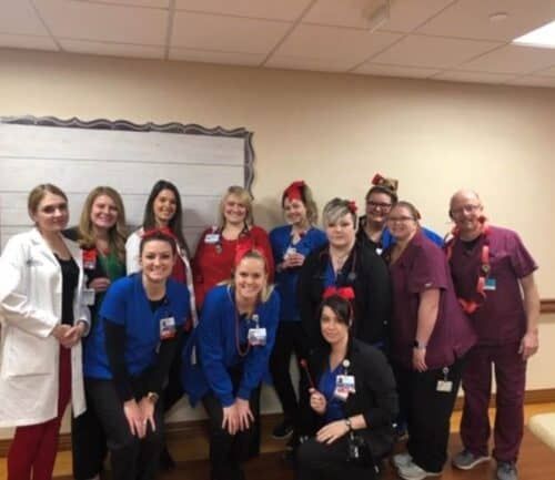 Healthcare team wearing red and blue scrubs posing together for Go Red for Women event