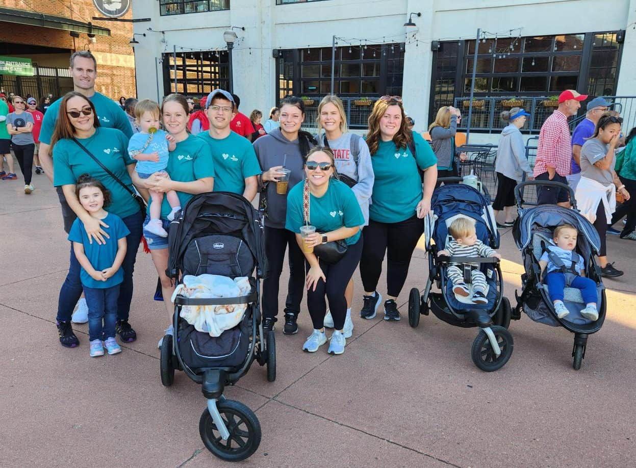 Group of families with strollers and children participating in community heart walk event