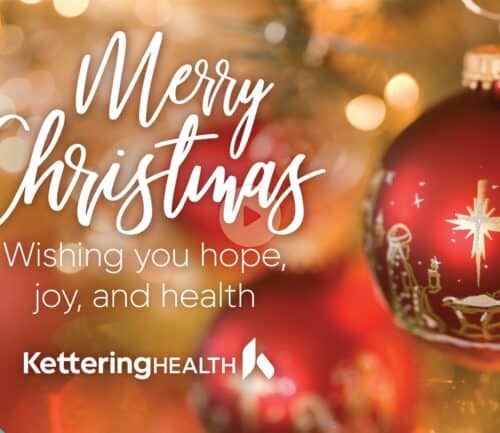 Christmas ornament with nativity scene beside "Merry Christmas" text and Kettering Health logo