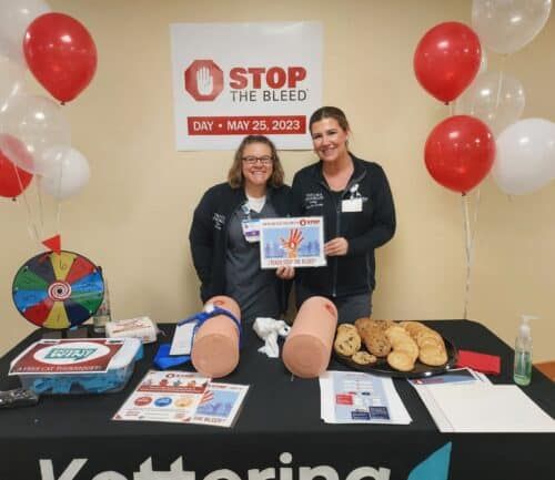 Two healthcare staff members at Stop the Bleed training event with medical demonstration equipment