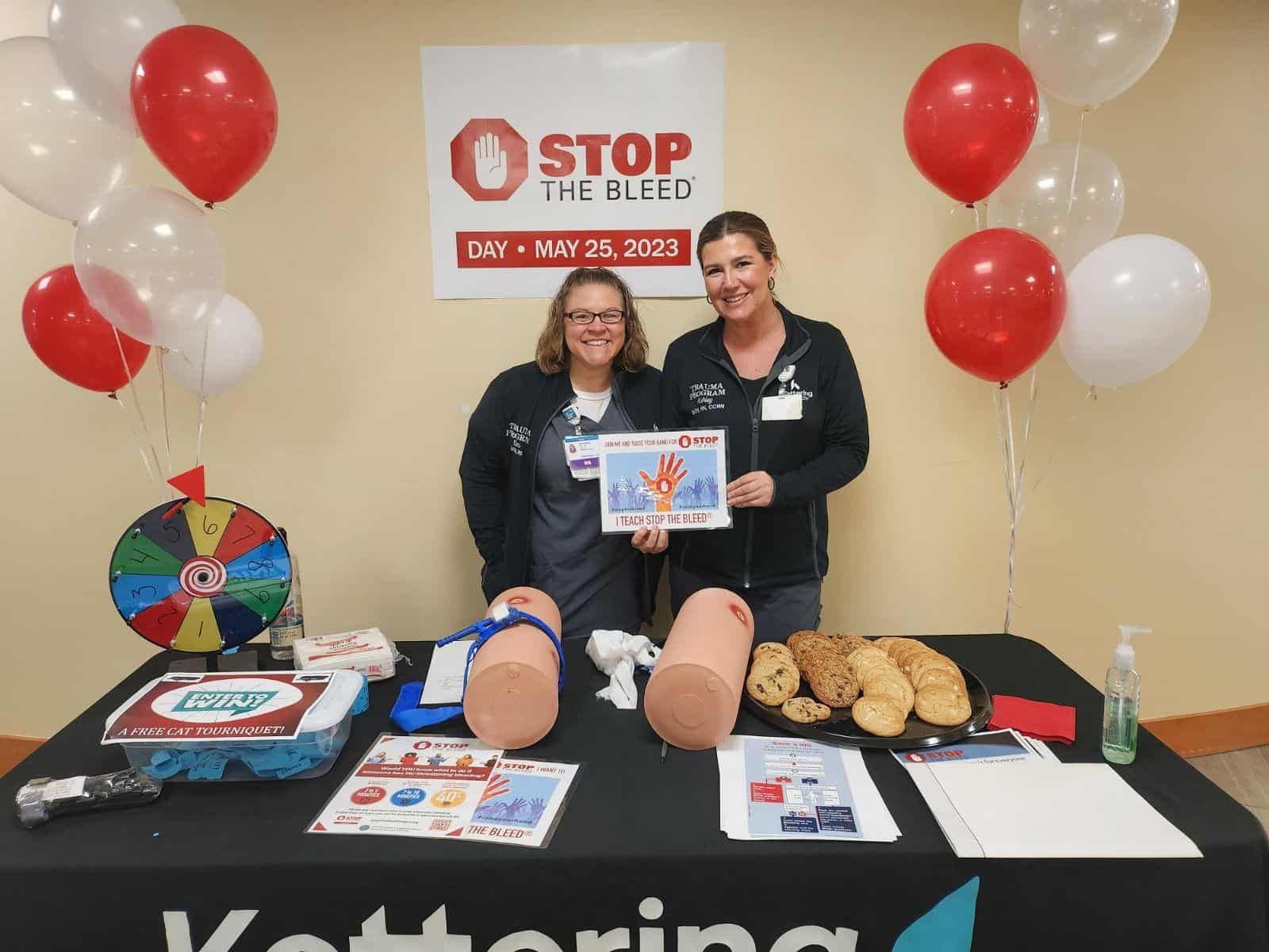 Two healthcare staff members at Stop the Bleed training event with medical demonstration equipment