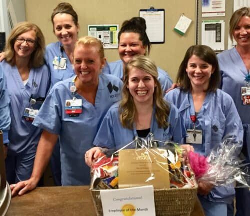 Healthcare team celebrates Employee of the Month winner with congratulatory basket and flowers