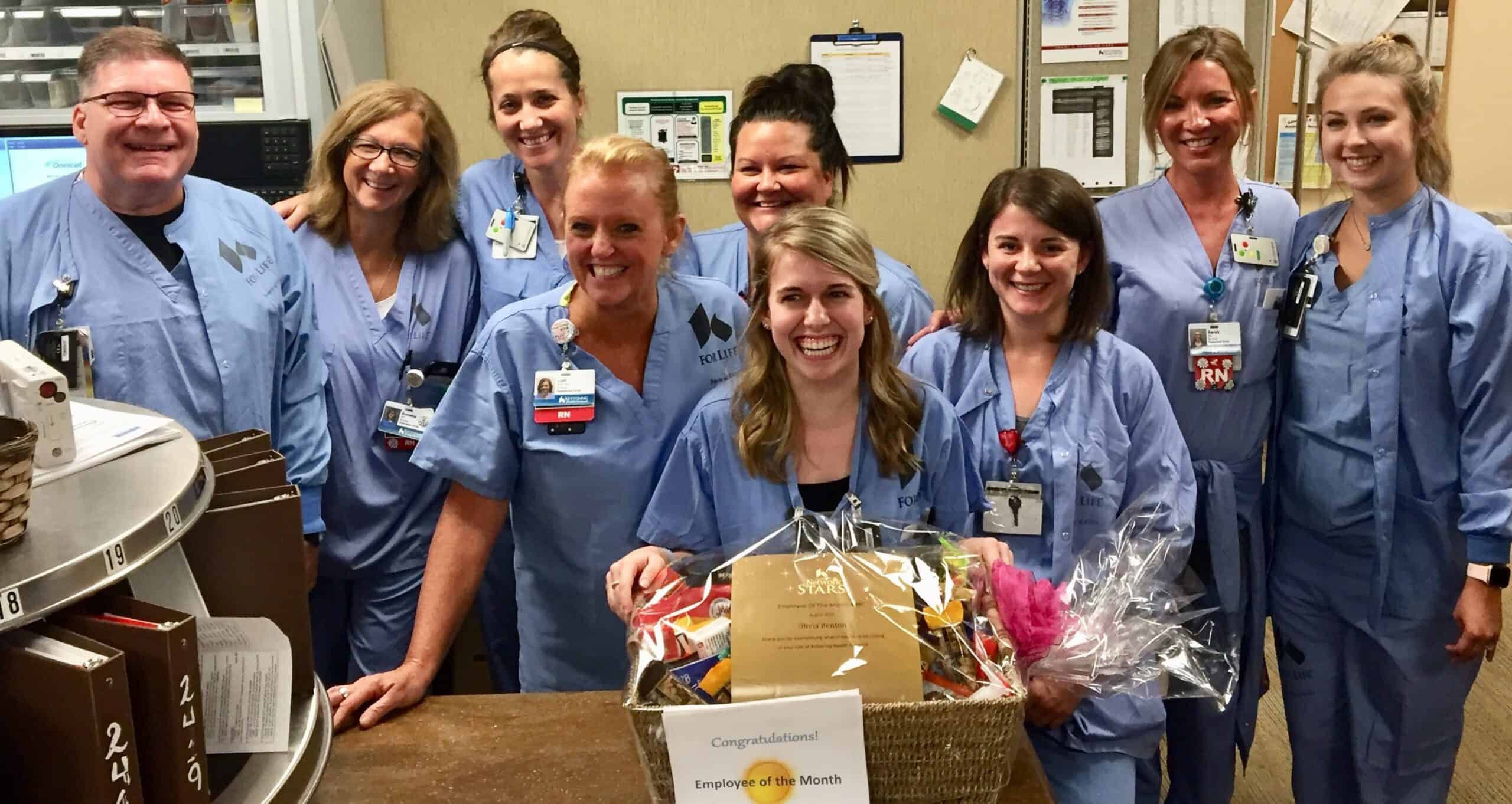 Healthcare team celebrates Employee of the Month winner with congratulatory basket and flowers