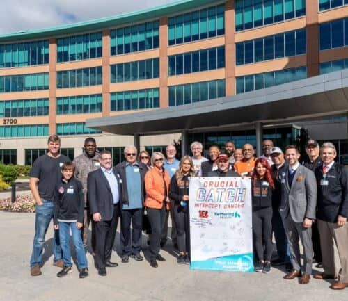 Group of people holding "Crucial Catch" cancer awareness sign outside Kettering Health Cancer Center