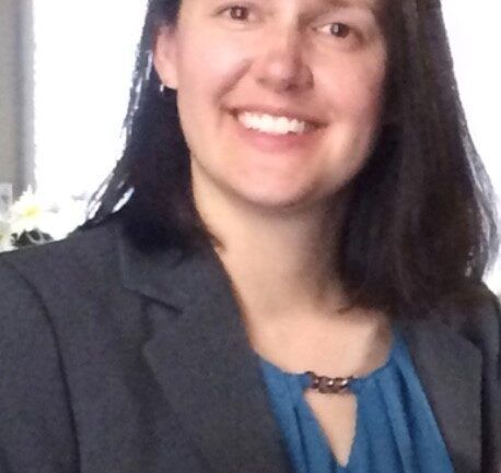 Professional headshot of Mandy in blue blouse and gray blazer smiling at camera