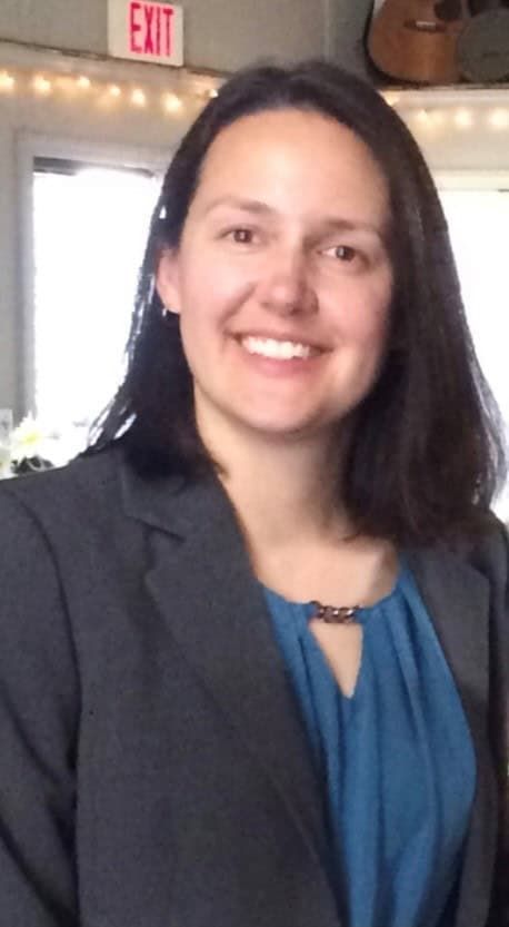 Professional headshot of Mandy in blue blouse and gray blazer smiling at camera