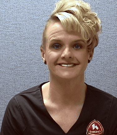 Professional headshot of Michelle, healthcare provider wearing dark scrubs with medical logo