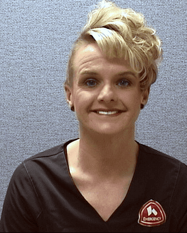 Professional headshot of Michelle, healthcare provider wearing dark scrubs with medical logo
