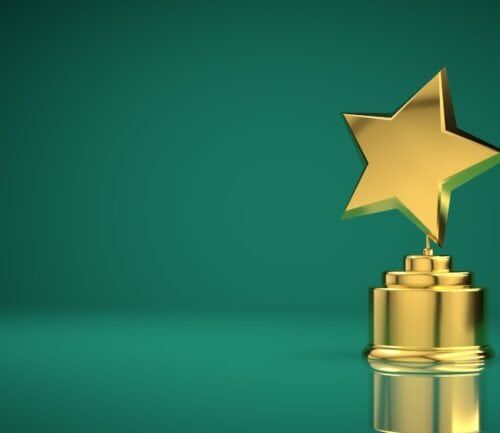 Golden star trophy award on green background for healthcare recognition