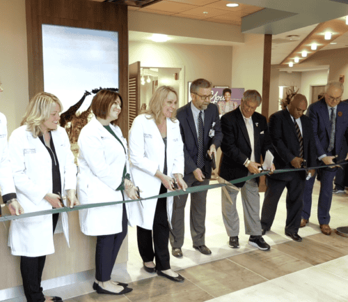 Medical professionals and executives cutting ribbon at Kettering Health facility opening ceremony