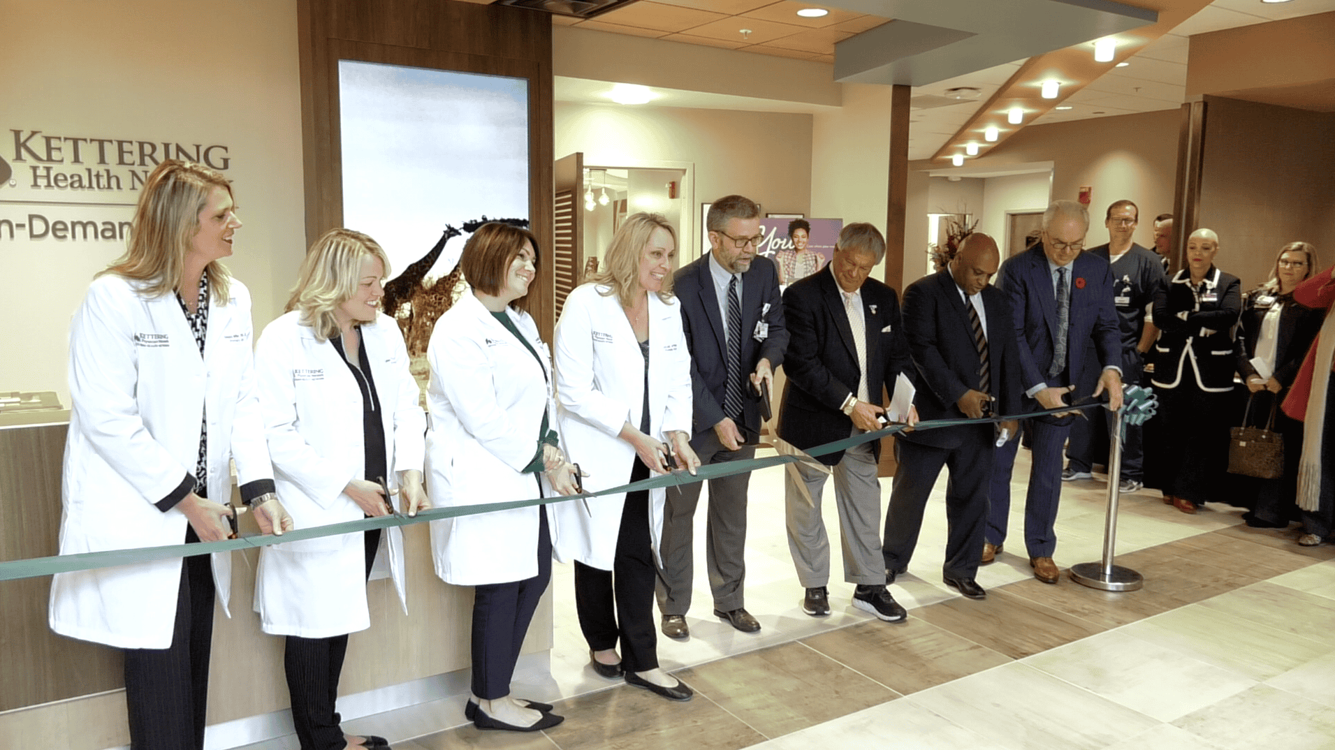 Medical professionals and executives cutting ribbon at Kettering Health facility opening ceremony