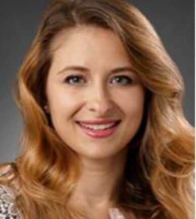 Professional headshot of Parizh, smiling woman with blonde wavy hair
