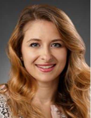 Professional headshot of Parizh, smiling woman with blonde wavy hair