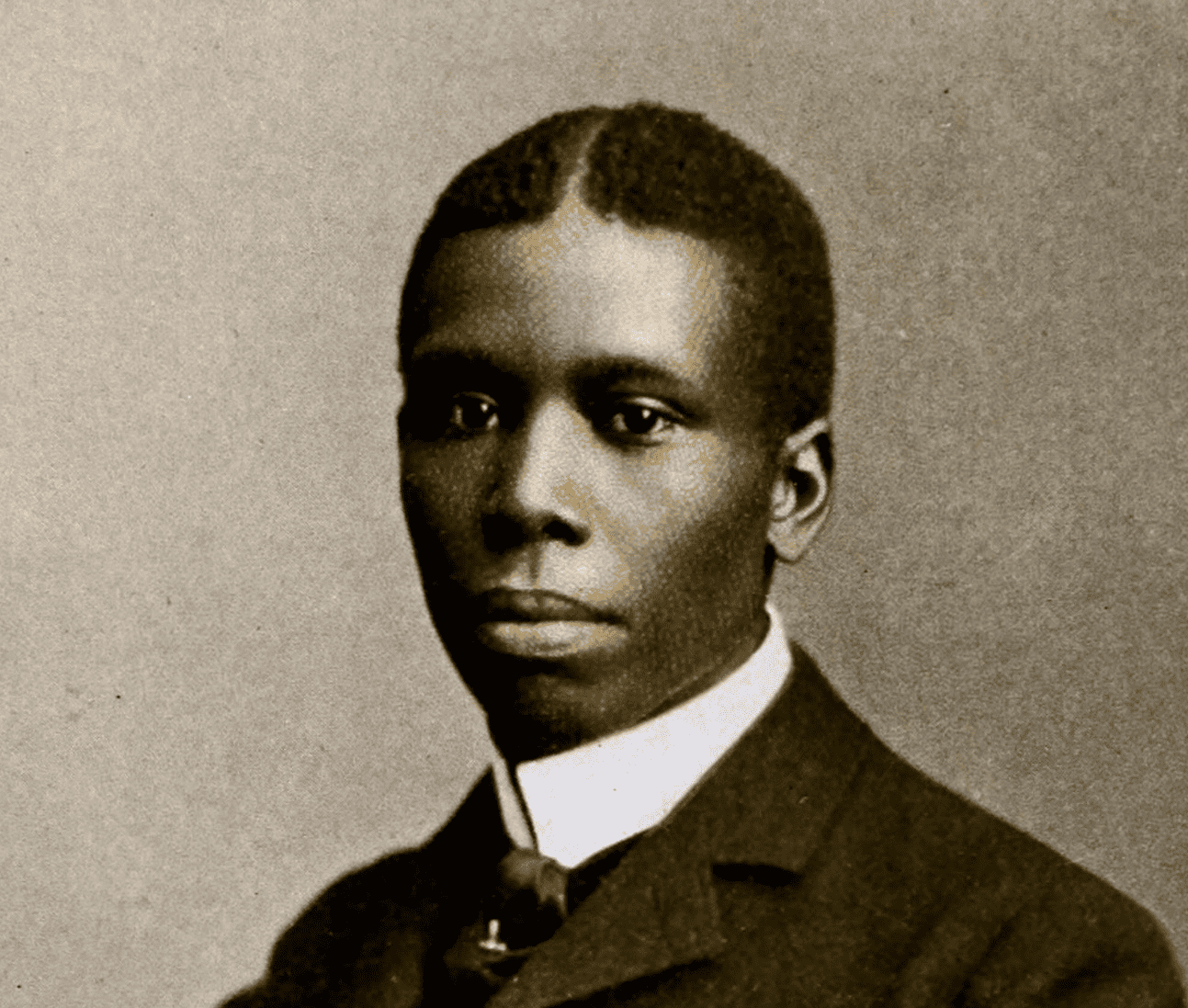 Historical portrait of Paul Laurence Dunbar in formal Victorian-era suit and collar.