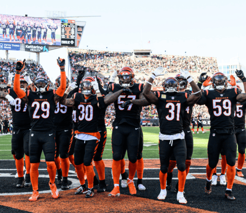 Cincinnati Bengals players celebrating with arms raised in end zone at stadium