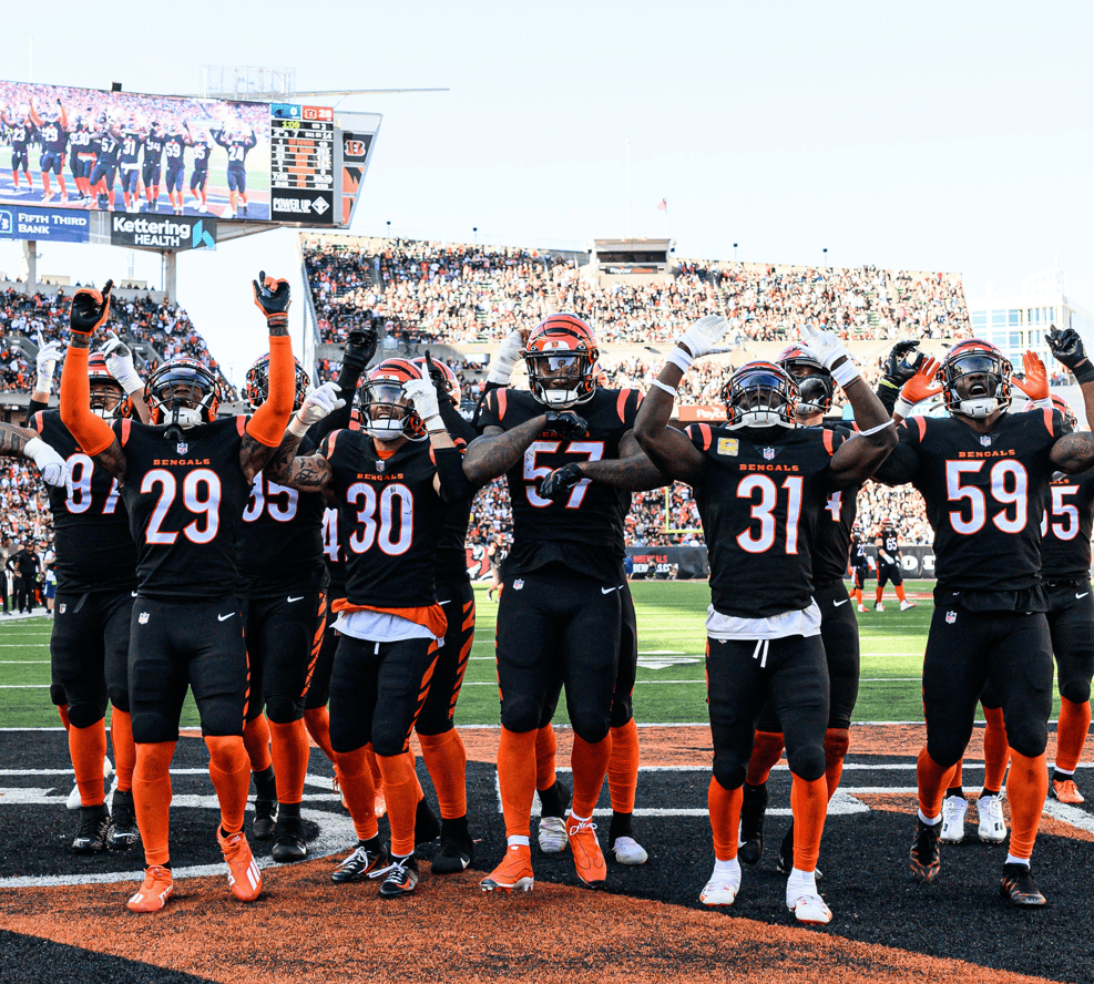 Cincinnati Bengals players celebrating with arms raised in end zone at stadium