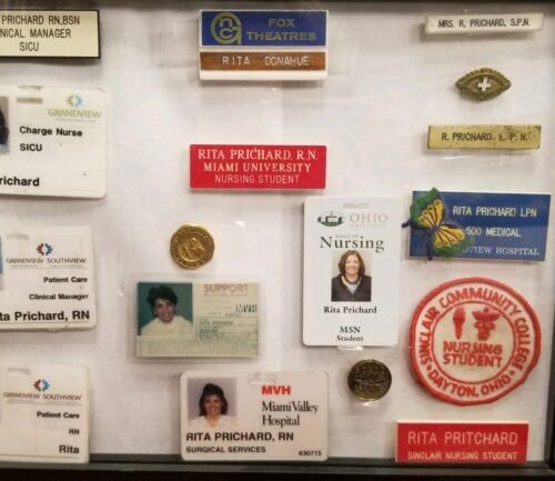 Collection of nursing name badges and ID cards for Rita Prichard displayed in frame