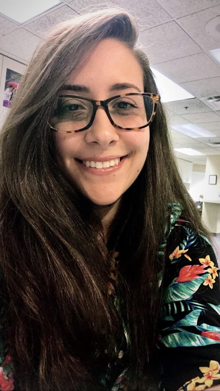 Professional headshot of Roberta Vieira de Oliveira wearing glasses and tropical print top