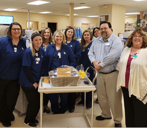 Healthcare staff celebrating with gift basket in hospital setting