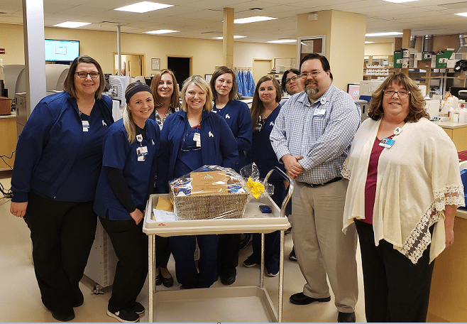 Healthcare staff celebrating with gift basket in hospital setting