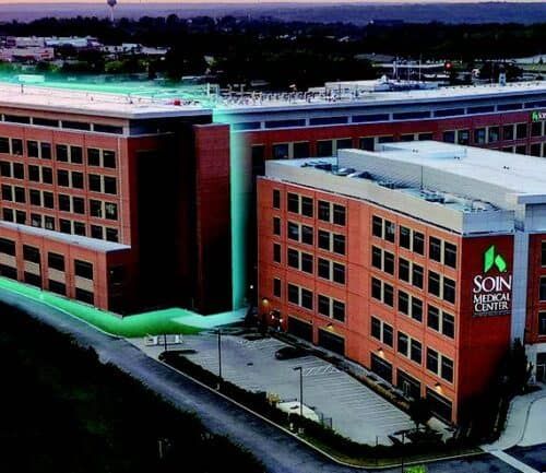 Aerial view of Soin Medical Center building with red brick exterior and green lighting