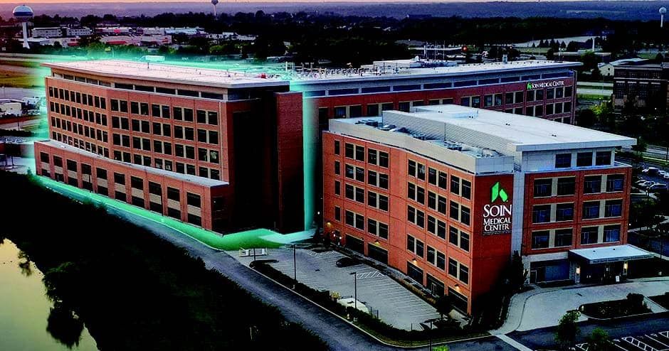 Aerial view of Soin Medical Center building with red brick exterior and green lighting