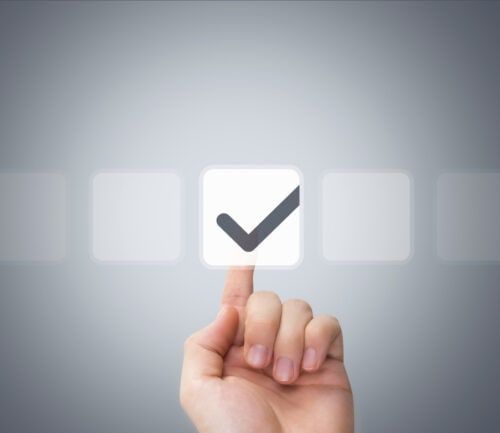 Hand pointing at checkmark icon among selection of digital interface buttons