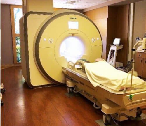 MRI machine with patient table in medical facility room at Kettering Health Sycamore