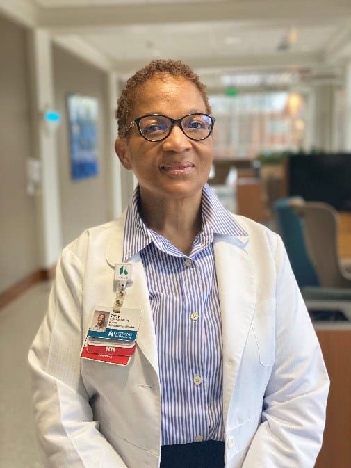 Professional headshot of Terry Moore in white coat standing in hospital hallway