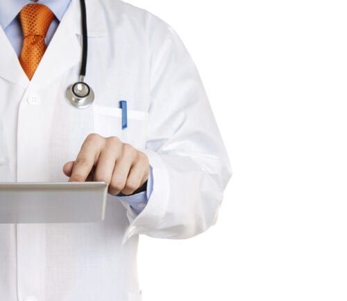 Doctor in white coat with stethoscope using tablet computer
