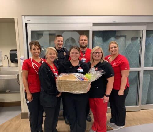 Healthcare team presenting gift basket to employee in hospital setting