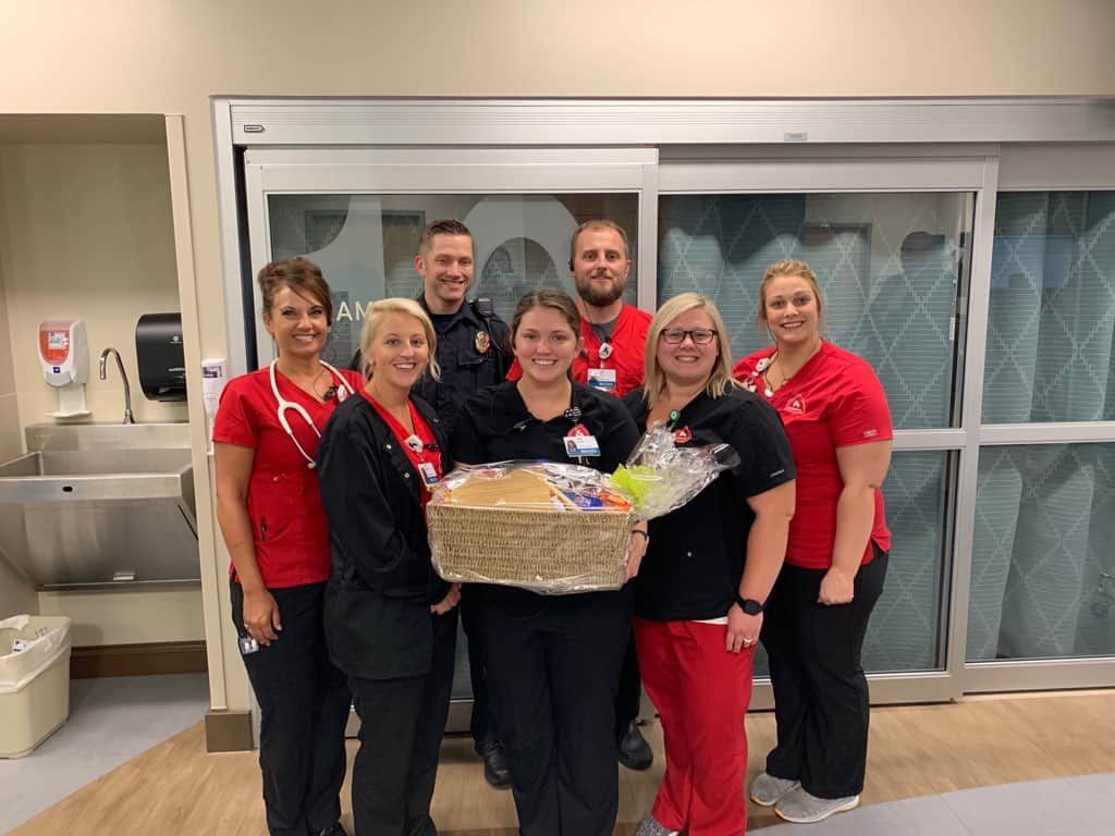 Healthcare team presenting gift basket to employee in hospital setting