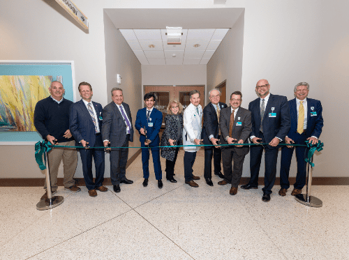 Group of professionals participating in ribbon cutting ceremony for new cancer care facility
