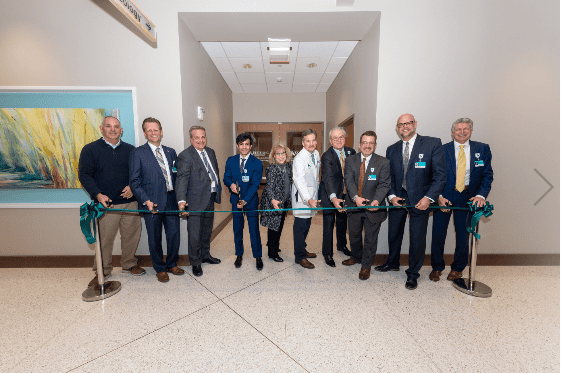 Group of professionals participating in ribbon cutting ceremony for new cancer care facility