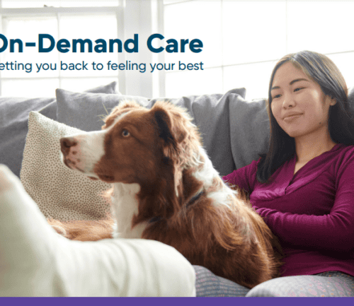 Woman resting on couch with dog, promoting Kettering Health's on-demand care services