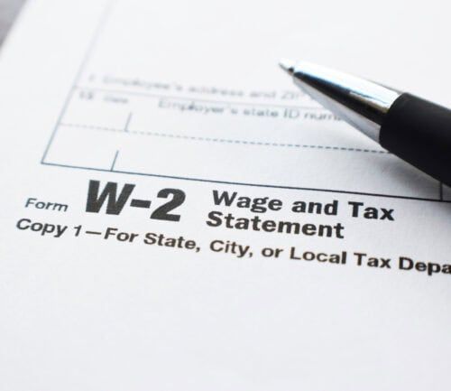 W-2 tax form with black pen, showing wage and tax statement details