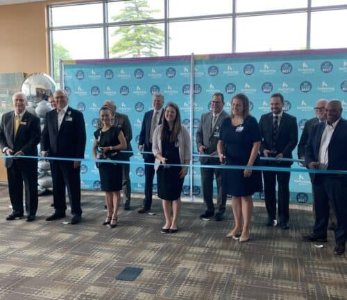 Group of executives participating in ribbon cutting ceremony at Kettering Health facility opening