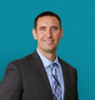 Professional headshot of Alexander Roux, PA-C in dark suit against teal background