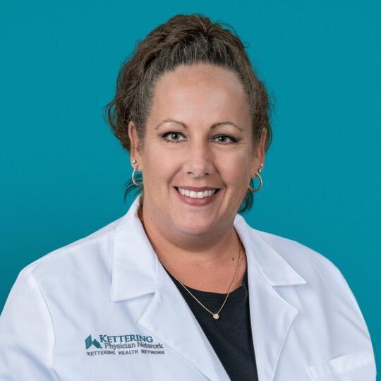 Professional headshot of Brandie L. McGuire, APRN-CNP in white medical coat