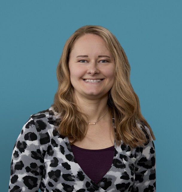 Professional headshot of Caitlyn Frantz, APRN-CNP, smiling in leopard print cardigan