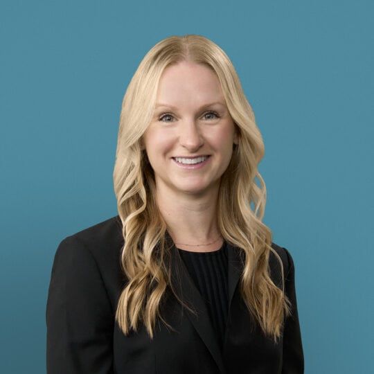 Professional headshot of Claire Healy, DO, smiling woman with blonde hair in black blazer