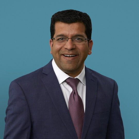 Professional headshot of Dakshin Gangadharamurthy, MD in navy suit and burgundy tie