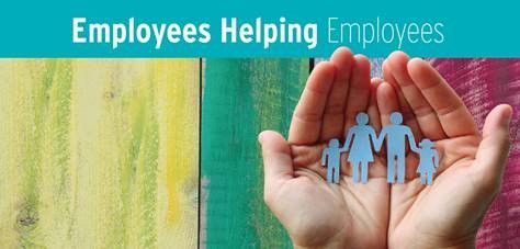 Cupped hands protecting paper cutout family figures with colorful wooden background