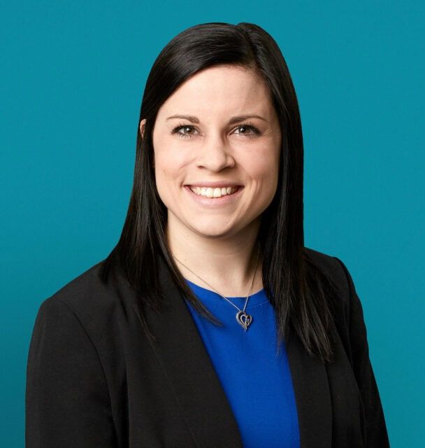 Professional headshot of Erin M. Haston, PA-C in blue top and black blazer